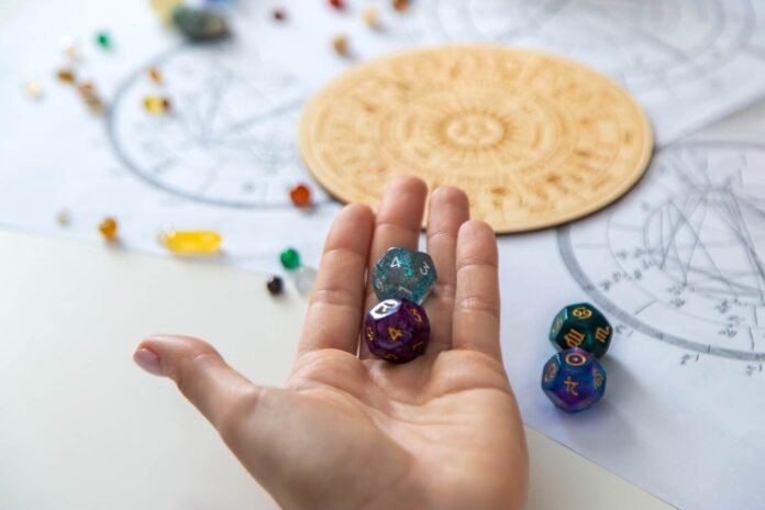 Astrologiniai simboliai ir daugiasieniai kauliukai ant stalo su horoskopo schemomis – simbolinis vaizdas „2025 m. rugpjūčio horoskopui“