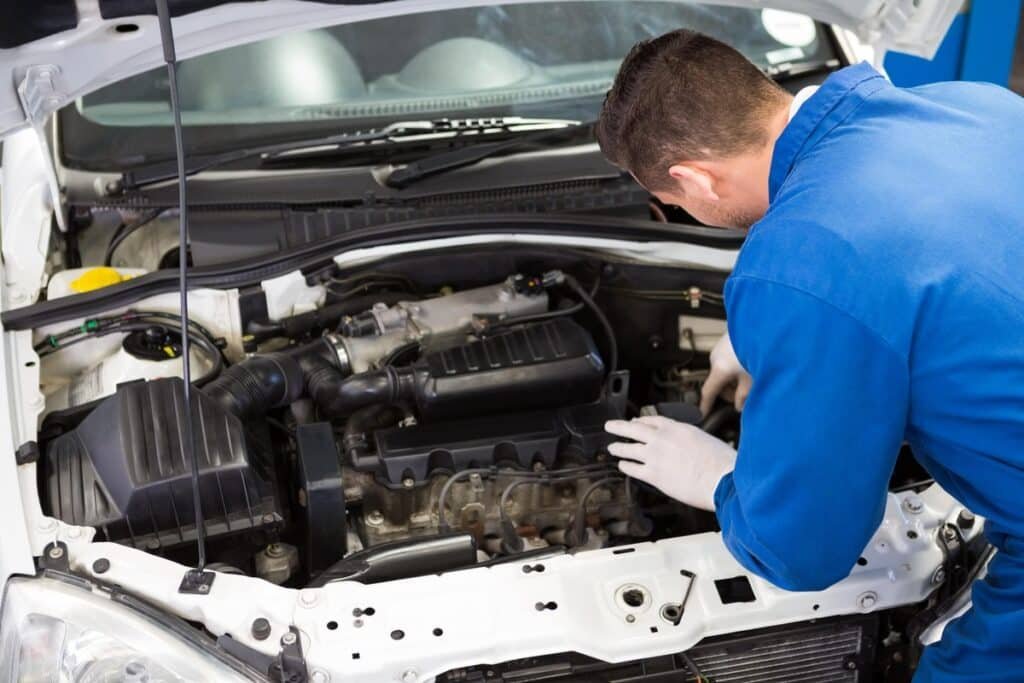 Specialistas autoservise atlieka automobilio variklio patikrą – automobilio variklio apsauga pailgina eksploatacijos laiką.