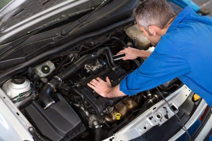 Mechanikas tikrina automobilio variklį – automobilio variklio apsauga nuo pažeidimų ir užtikrinamas patikimumas kelyje.